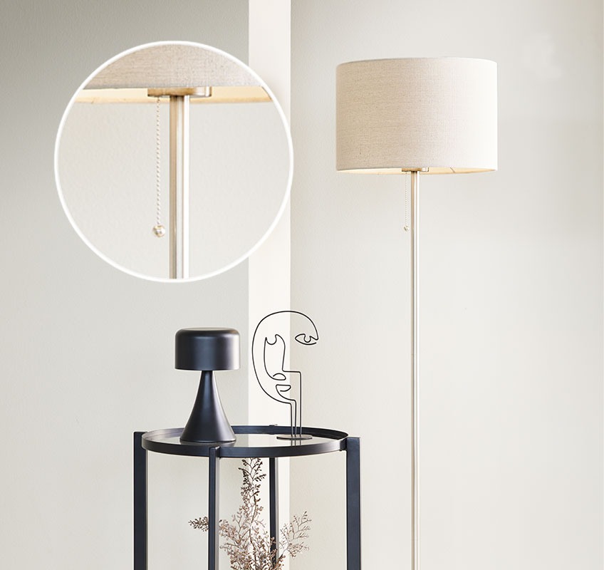 White floor lamp and black side table with decorative ornaments